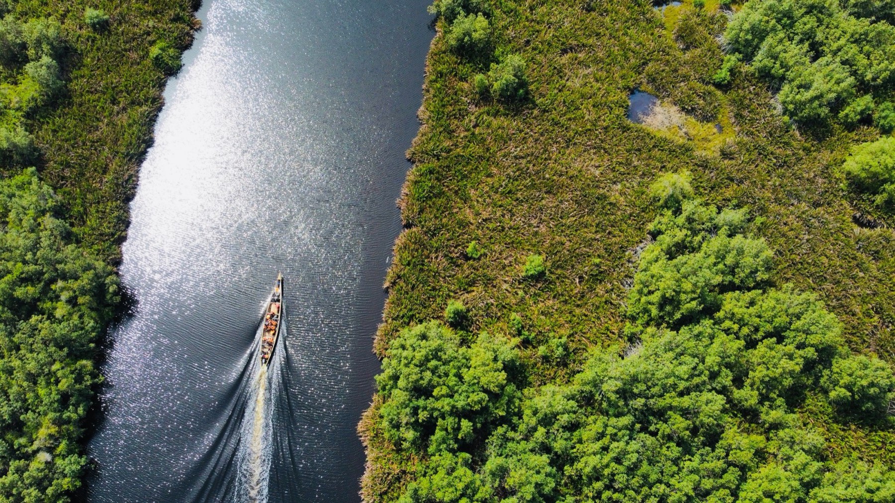 Aerial view of a boat moving along the Volta river corridor